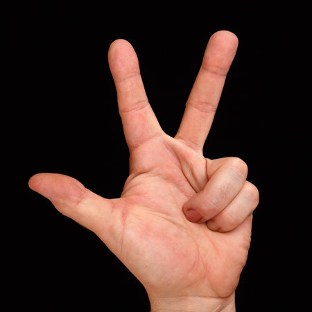 Mans hand shows three fingers.の写真素材