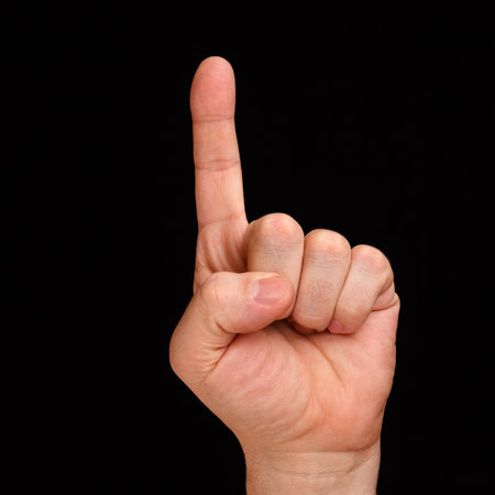 Forefinger. A mans hand shows one finger on a black backgroundの写真素材