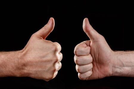 Two hands showing approval, on a black backgroundの写真素材