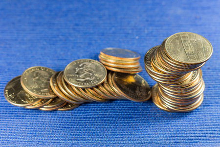 Money coins in a pile on blue background.
