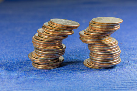 Money coins in a pile on blue background.