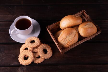 Home made cookies and buns in bread basket on a wooden background, low keyの写真素材