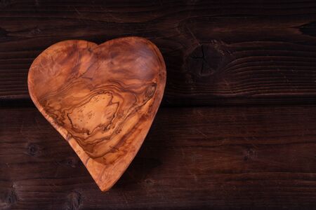 Plate heart shape on a wooden background, low key, hand made, rusticの写真素材