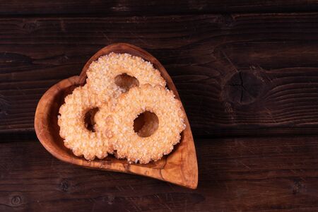 Plate heart shape with cookies on a wooden background, low key, hand made, rusticの写真素材