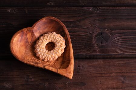 Plate heart shape with cookies on a wooden background, low key, hand made, rusticの写真素材