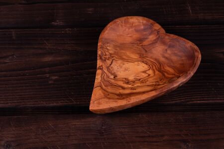 Plate heart shape on a wooden background, low key, hand made, rusticの写真素材