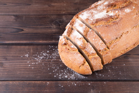 Fresh baked and sliced bread on rustic wooden table