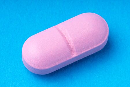 pink pills on a blue background. omega3. vitaminsの写真素材