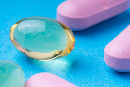 pink pills and omega3 on a blue background. omega3.の写真素材