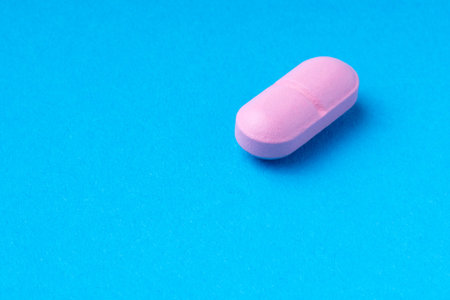 pink pills on a blue background. omega3. vitaminsの写真素材