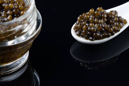 Black sturgeon caviar in ceramic spoon. macro.の写真素材