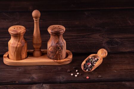 Small wooden spoon for spices with pepper, low key, olive wood, rustic.の写真素材