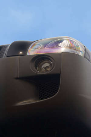 Headlight of a car. Upward shot. Sky is visible.の写真素材
