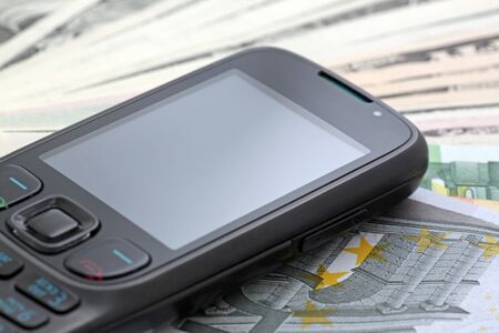 Mobile phone on a cash (dollars and euro)の写真素材