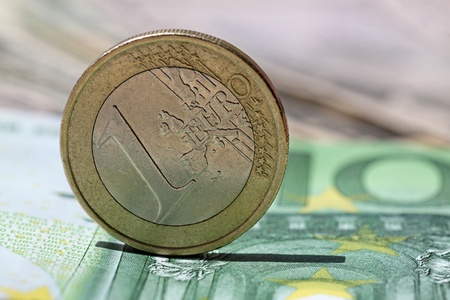 one euro coin on one hundred  euro banknoteの写真素材