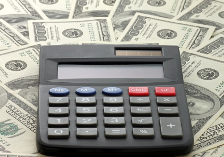 calculator on one hundred dollars banknotesの写真素材