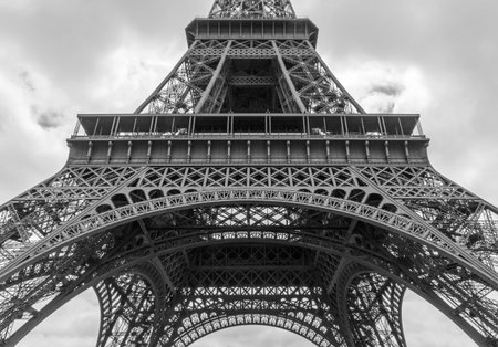 detail of Eiffel tower against clouds in black and white