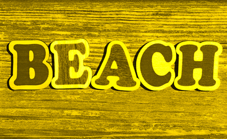 word beach on yellow wood backgroundの写真素材