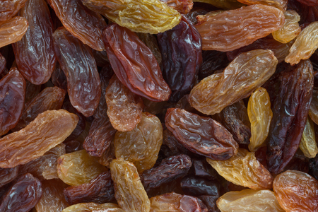 close up of dark brown and golden raisins backgroundの写真素材
