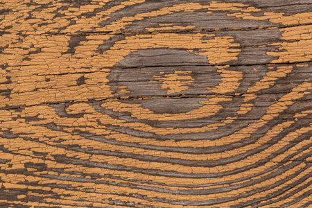 close up of old wooden board partially painted in yellow