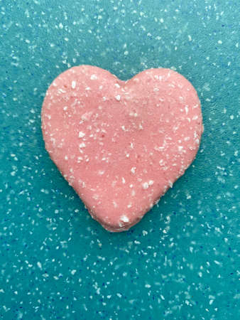 Day of Valentine background: valentine shaped cookie with coconut shavings lying on aqua boardの写真素材