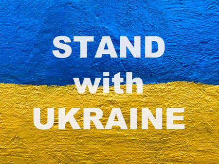 Stand with Ukraine losung on wall painted as Ukrainian national flagの写真素材
