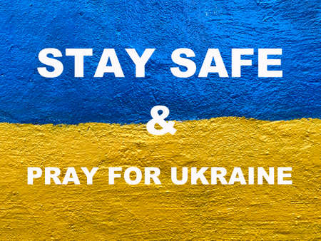 Stay Safe and Pray for Ukraine message on Ukrainian flag painted on wallの写真素材