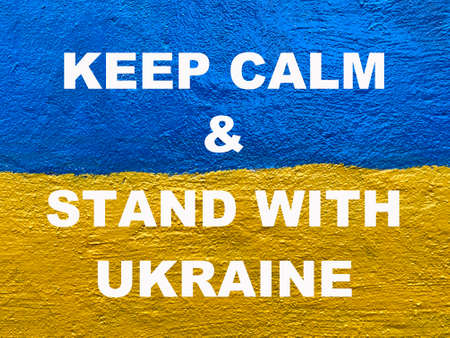 message Keep calm and stand with Ukraine on Ukrainian flag painted on wallの写真素材