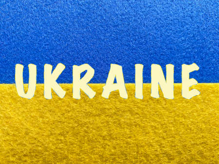 word Ukraine sewed to Ukrainian flag made of feltの写真素材
