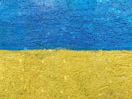 Stand with Ukraine: Ukrainian flag painted on stone wallの写真素材
