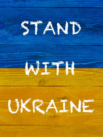 slogan Stand with Ukraine on Ukrainian flag painted on wooden wallの写真素材
