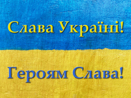 message Glory to Ukraine, Glory to Heroes in Ukrainian on flag painted on wallの写真素材