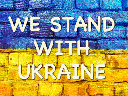 message We stand with Ukraine on Ukrainian flag painted on brick wallの写真素材