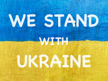 message We stand with Ukraine on Ukrainian flag painted on stone wallの写真素材