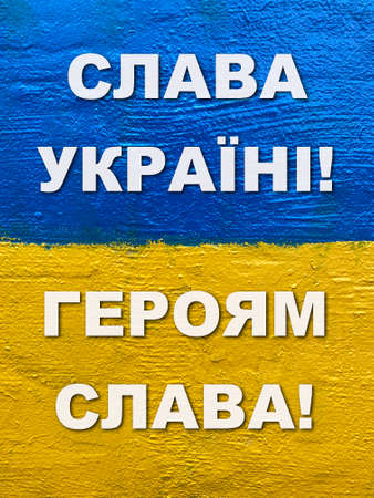 message Glory to Ukraine, Glory to Heroes in Ukrainian on flag painted on wallの写真素材
