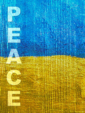 Stand with Ukraine: word Peace on Ukrainian flag painted on wooden wallの写真素材