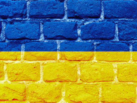 Stand with Ukraine backdrop: Ukrainian flag painted on brick wallの写真素材