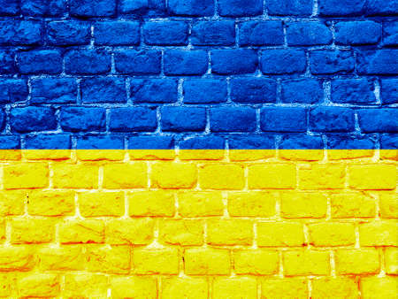 Stand with Ukraine backdrop: Ukrainian flag painted on brick wallの写真素材