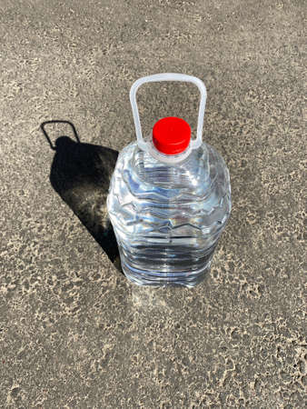 plastic bottle with clean water standing on road at sunlightの写真素材