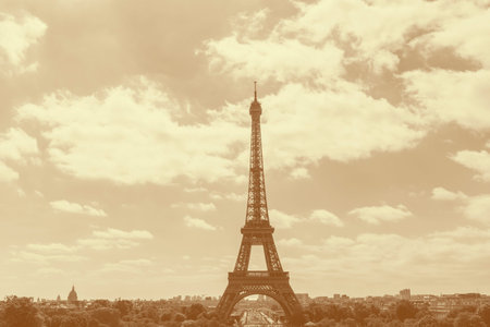 sight of Paris with Eiffel Tower against cloudy sky colored in yellow