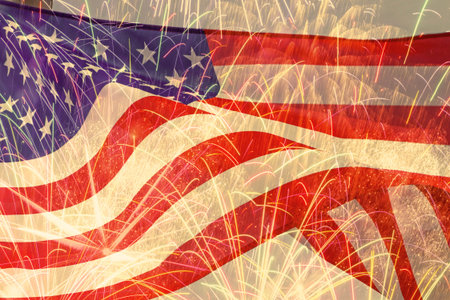 close up of waved United States flag against fireworks in night sky