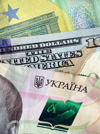 currency exchange: close up of Ukrainian hryvnia, euro and USD banknotesの写真素材
