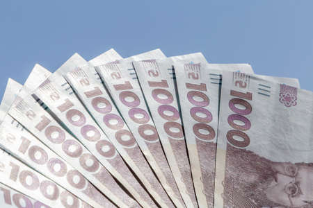 fan-shaped five hundred Ukrainian hrivnya banknotes against blue skyの写真素材