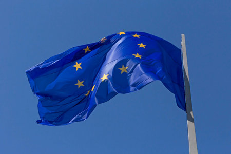 close up of waved European Union flag on flagpole against blue skyの写真素材