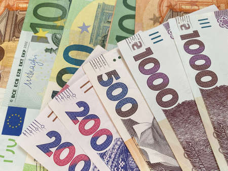 currency exchange: several Ukrainian hrivnya banknotes against euro banknotesの写真素材
