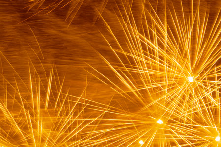 abstract holiday background: yellow fireworks in night skyの写真素材