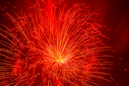 abstract holiday background: yellow fireworks against red smokeの写真素材