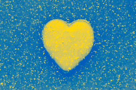 valentine shaped cookie on abstract plastic background colored in colors of Ukrainian flagの写真素材