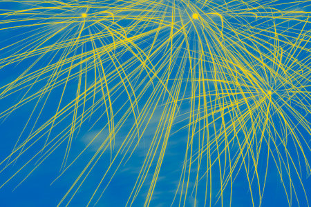 abstract holiday background: close up of fireworks in night sky colored in colors of Ukrainian flagの写真素材