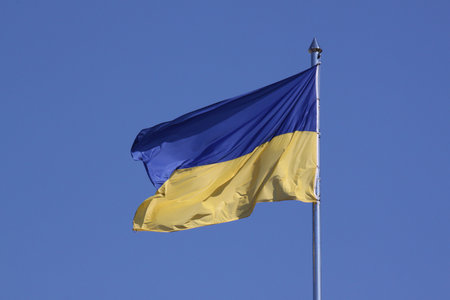 waved flag of Ukraine on flagpole against blue skyの写真素材